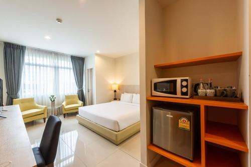a hotel room with a bed and a tv at Paeva Luxury By Nakra Functionality in Bang Bo