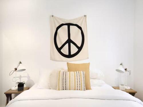 a bedroom with a peace sign hanging above a bed at Cronulla beach apartments in Cronulla