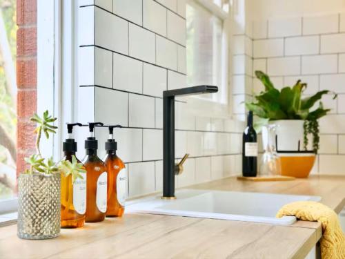 a kitchen sink with bottles of wine on a counter at Cronulla beach apartments in Cronulla