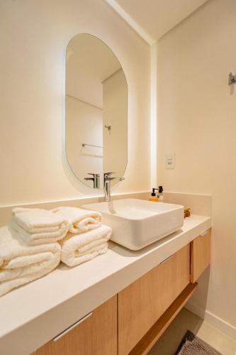 a bathroom with a white sink and a mirror at Loft no Granja Brasil Resort, Itaipava centro, Estrutura Completa in Araras Petropolis