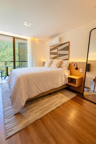 a bedroom with a large bed and a large window at Loft no Granja Brasil Resort, Itaipava centro, Estrutura Completa in Araras Petropolis