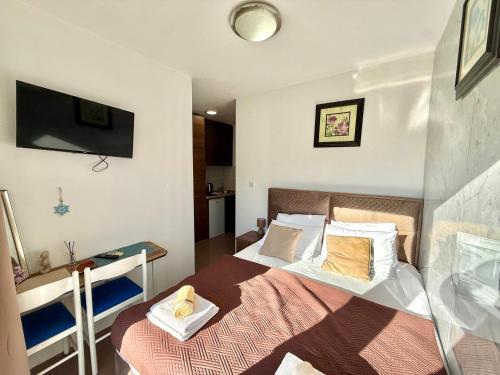a bedroom with a bed and a tv on the wall at Beachfront Bliss in Đenovići
