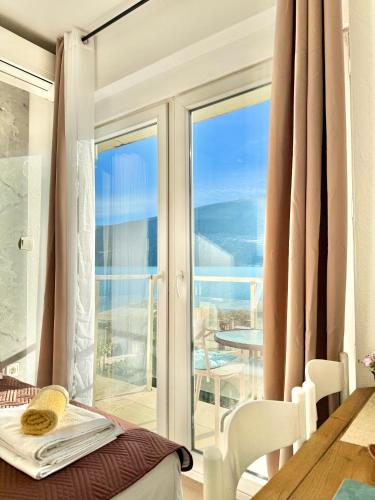 a room with a balcony with a view of the ocean at Beachfront Bliss in Đenovići