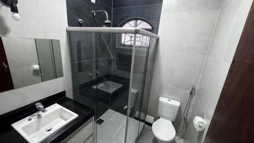 a bathroom with a shower and a sink and a toilet at Casa Aparecida in Uberlândia