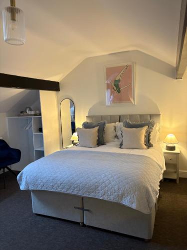 a bedroom with a large bed with white sheets and pillows at The Dozy Deer in Windermere