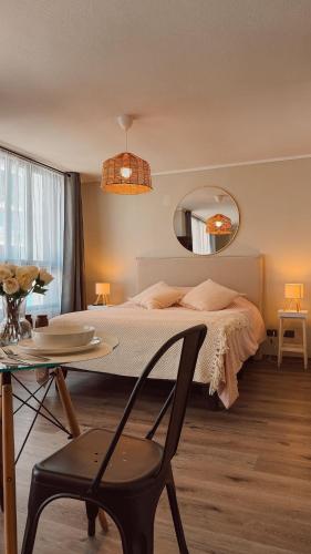 a bedroom with a bed and a table and a mirror at Getaway in Valparaiso in Valparaíso