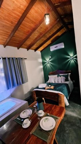 a room with a bed and a table with plates on it at Chalé Corina in Pirenópolis
