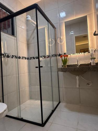 a bathroom with a shower and a toilet and a sink at Serra Charm House in Ubajara