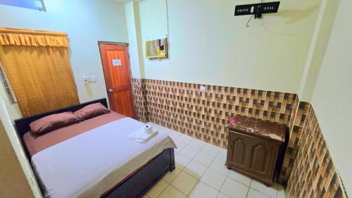 a bedroom with a bed and a tiled wall at Hospedaje RIO BLANCO in Iquitos