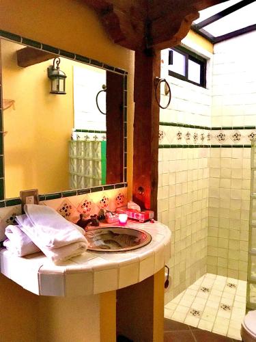 a bathroom with a sink and a shower with a mirror at Hotel Casa Santos Guanajuato in Guanajuato