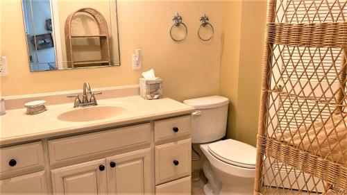 a bathroom with a sink and a toilet and a mirror at Flip Flop Beach in Cape May Point