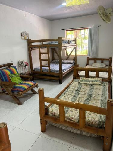 a room with several bunk beds and a chair at Finca el milagro Melgar in Melgar