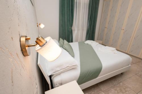 a room with a bed with a towel on the door at Port Haven Suite Civitavecchia in Civitavecchia