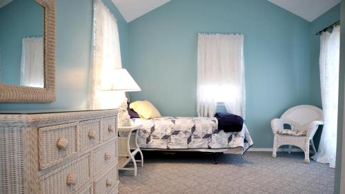 a bedroom with a bed and a dresser with a mirror at Failte in West Cape May