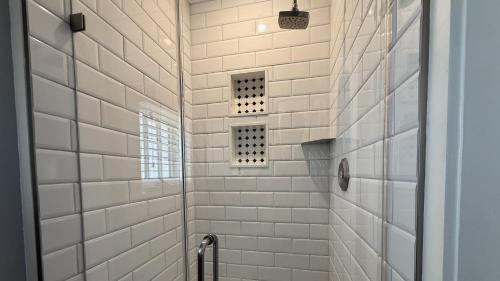 a bathroom with a shower with white tiles at Windsor Escape in Cape May