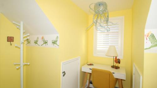 a yellow room with a desk and a window at Dunescape in West Cape May