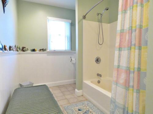 a bathroom with a shower and a bath tub at Cedar Cottage in Cape May Point