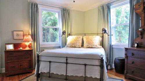 a bedroom with a bed with two windows and a dresser at 637 Seagrove in Cape May Point