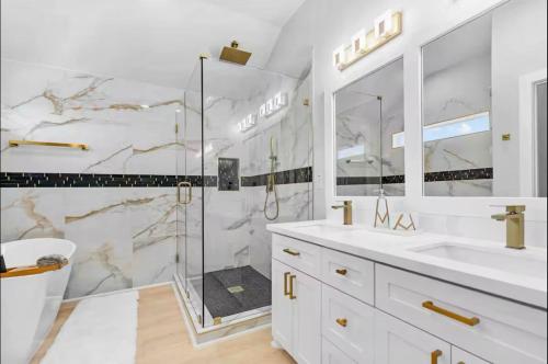 a white bathroom with a shower and two sinks at Villa De Briley - Luxury Creator Station - Fire Pit in Houston