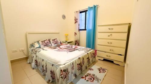 a small bedroom with a bed and a dresser at Cozy 1 bedroom in Punta Cana