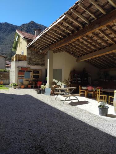 a patio with a table and chairs under a roof at La Pommeraie in Casteil