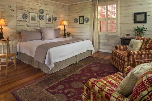 ein Schlafzimmer mit einem Bett, einem Sofa und einem Stuhl in der Unterkunft Glen-Ella Springs Inn in Clarkesville