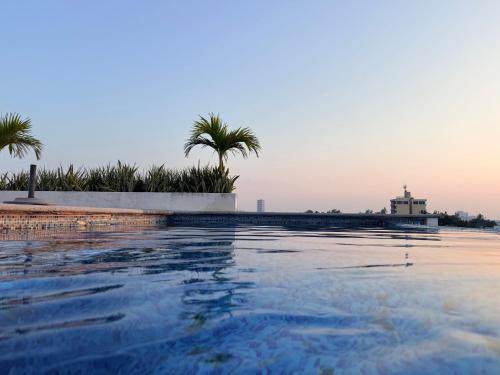 a swimming pool with palm trees in the background at Hermoso Departamento Moderno con alberca in Boca del Río