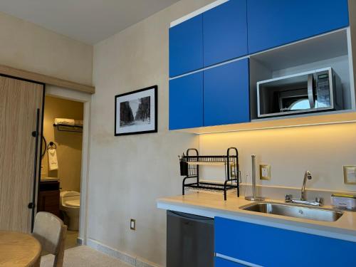 a kitchen with blue cabinets and a sink at Casa Filomeno in Mexico City