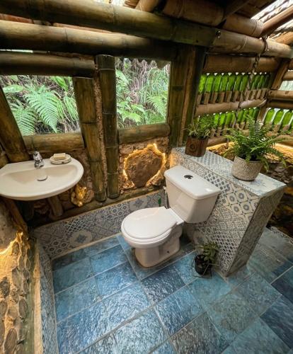 a bathroom with a toilet and a sink at Bosque Hondo Ecoliving in Medellín