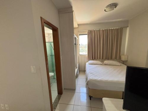 a bedroom with a bed and a window and a television at Flat in Caldas Novas in Caldas Novas