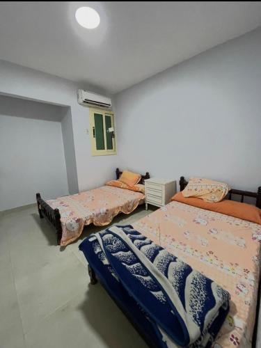 a bedroom with three beds in a room at قريه نڤيرت in Fayed