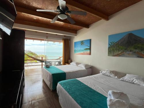 a bedroom with two beds and a ceiling fan at Hotel Punta del Mar in Máncora Chico