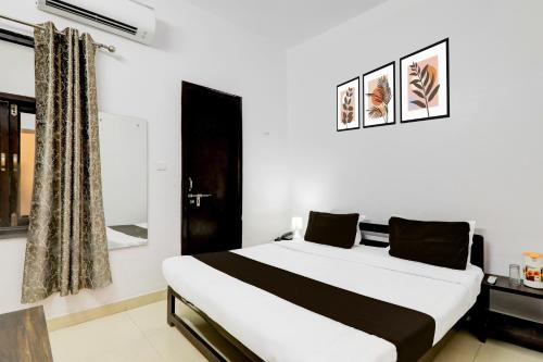 a bedroom with a large white bed and a window at Super OYO Hotel O Indira Nagar in Lucknow