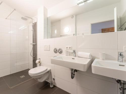 a white bathroom with a toilet and a sink at Emma Top 4 in Dienten am Hochkönig