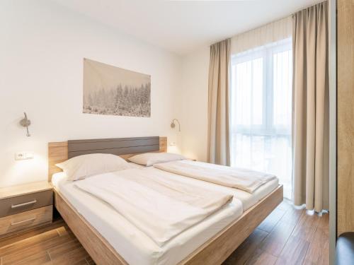 a bed in a bedroom with a large window at Emma Top 2 in Dienten am Hochkönig