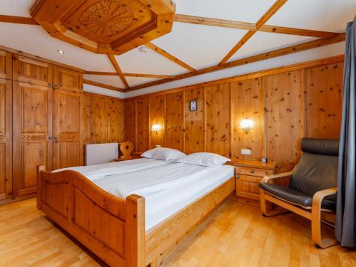a bedroom with a bed and a chair at Kitzbüheler Alpen XL in Bramberg am Wildkogel