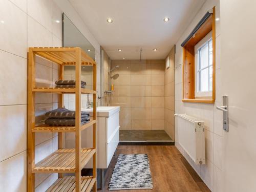 a bathroom with a wooden shelf and a sink at Kitzbüheler Alpen XL in Bramberg am Wildkogel