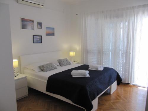 a bedroom with a bed with two towels on it at Apartments and rooms with a swimming pool Brist, Makarska - 15620 in Brist