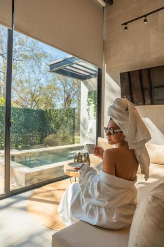 a woman sitting in a bed with a towel on her head at Epic Tamarindo Boutique Hotel in Tamarindo