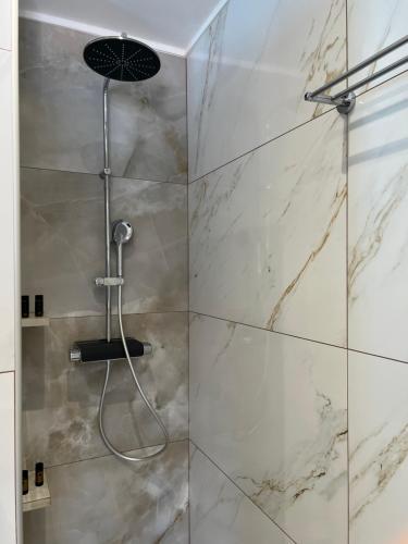 a bathroom with a shower with marble walls at Samos Blue Haven in Samos