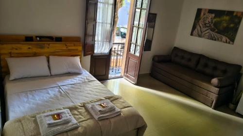 a bedroom with a bed and a couch and a window at La Cruz Apart in Corrientes