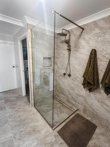 a shower with a glass door in a bathroom at Beach Bungalow Yeppoon in Yeppoon