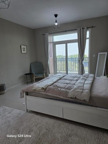 a bedroom with a bed and a large window at Cosy Studio - Desert Breeze in Ghantoot