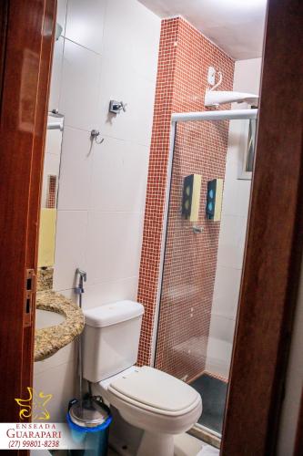 a small bathroom with a toilet and a shower at CONFORTO IMBATIVEL - 25 metros do MAR - 2 Quartos com AR CONDICIONADOS SPLIT, Air Fryer, WI-FI, Disney Plus, Star Plus, HBO Max, Cadeiras de Praia e Caixa Térmica - 8 pessoas com Muito Conforto - Melhor Localização! in Guarapari