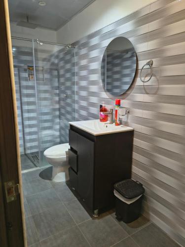 a bathroom with a sink and a toilet and a mirror at RICAURTE CASA PISCINA PRIVADA in Ricaurte