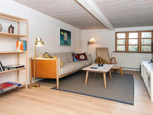 a living room with a couch and a table at House with beautiful garden in Glesborg