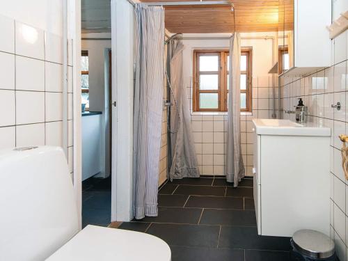 a bathroom with a toilet and a sink at House with beautiful garden in Glesborg