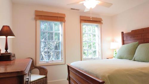 a bedroom with a bed and two windows at 639 Seagrove in Cape May Point