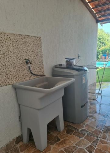 a bathroom with a sink and a trash can at Chácara Florida Boituva in Boituva