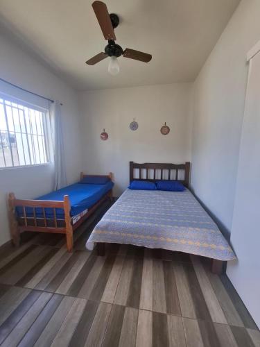 a bedroom with two beds and a ceiling fan at Chácara Florida Boituva in Boituva